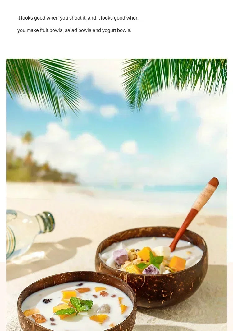 A bowl of coconut smoothie with fruit and herbs served in a natural coconut shell bowl on a sandy beach.