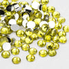 A pile of round, flatback resin rhinestones in yellow and clear colors.