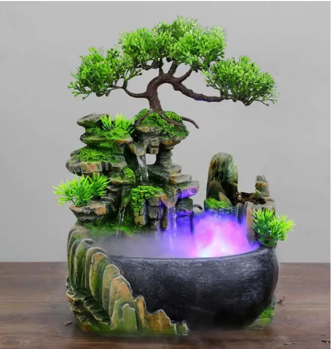 A resin waterfall desktop fountain featuring a mossy rock landscape and purple LED lighting.