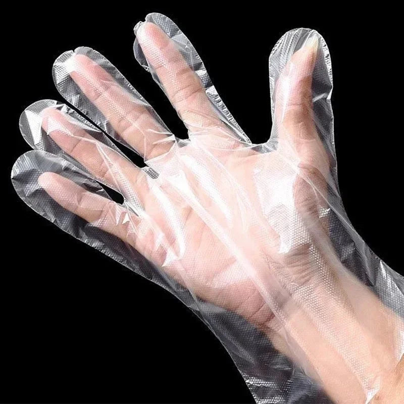 A hand wearing a clear disposable plastic glove for kitchen and food preparation.