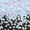 A pile of pink and white sea shell PVC sequins for nail art and craft decoration.