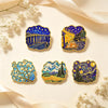 A set of five enamel pins featuring Van Gogh's art, including Starry Night and other classic paintings, displayed on a light 