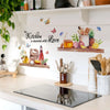 A white wall features a kitchen-themed decal with butterflies and the text seasoned with love.