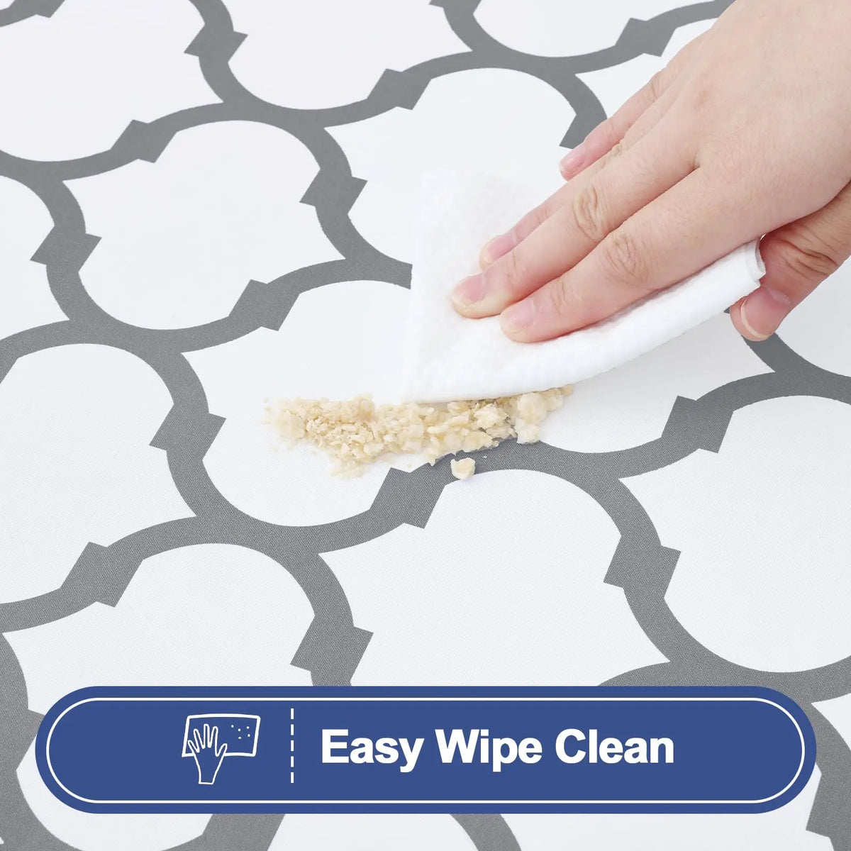 A hand wipes a patterned surface with a white cloth, demonstrating easy wipe clean functionality.