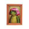 A painting of a green frog with pink hair inside an orange wooden photo frame.