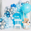 A cluster of blue and light blue latex balloons arranged around a white chair for a birthday party theme.