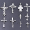 A collection of antique silver cross charms and pendants for jewelry making displayed on a dark gray background.