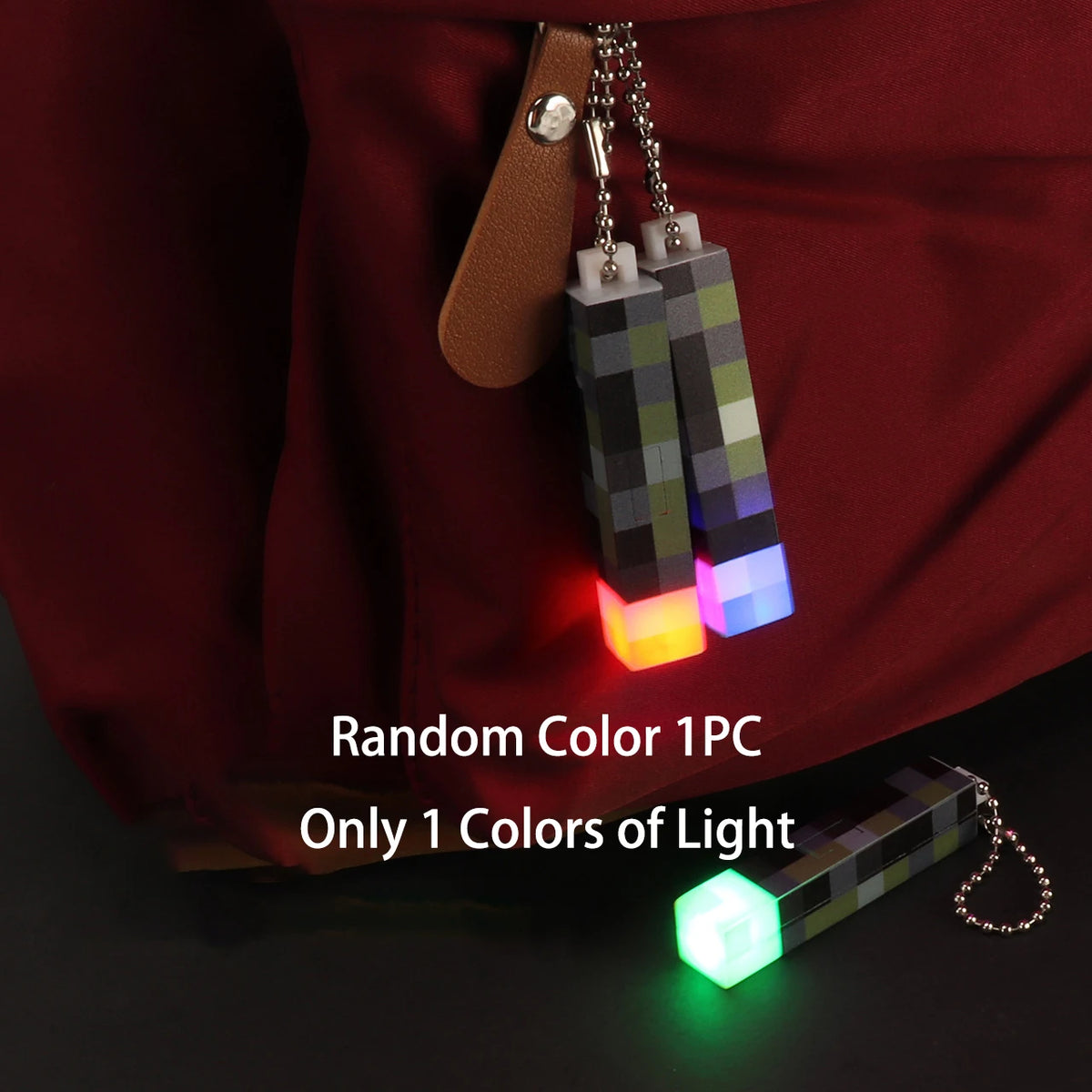 A random color pixel art flashlight keychain with multiple colored LEDs hanging from a leather strap.