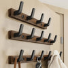 A wooden coat rack with eight black hooks mounted on a wall, featuring a storage shelf.
