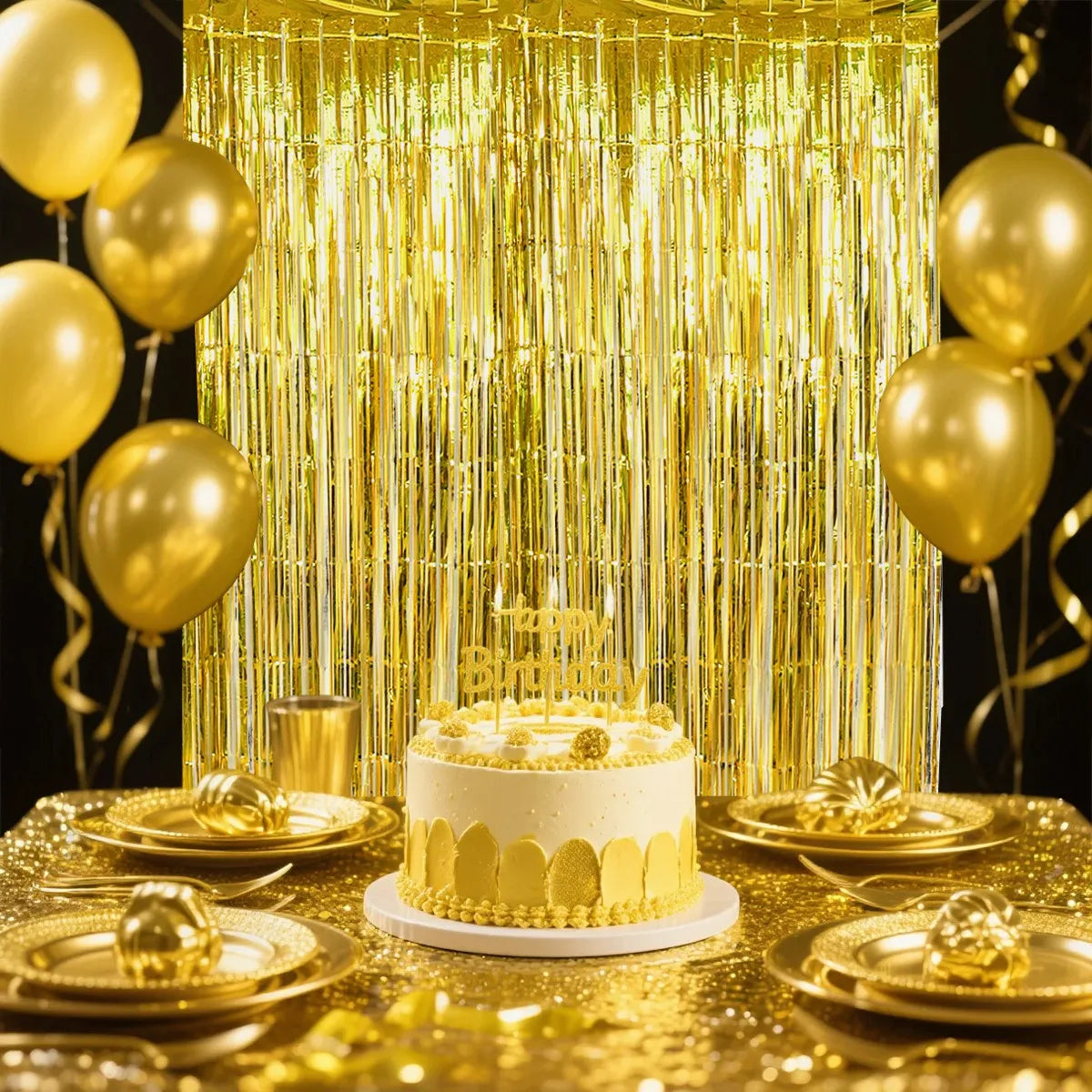 A golden sequin glitter party backdrop with hanging gold streamers and a cake on a gold-draped table.