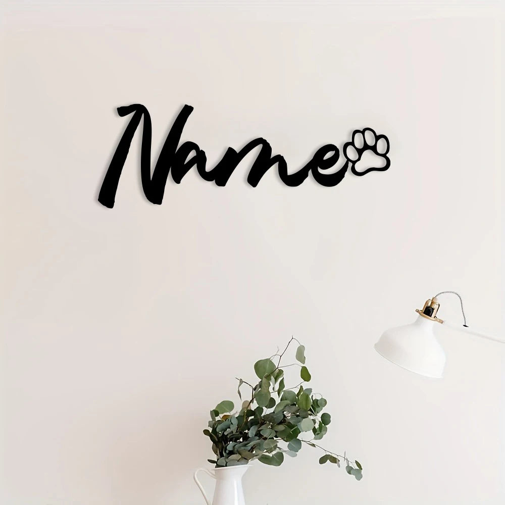 Black script text spelling Name with a paw print silhouette on a white wall.