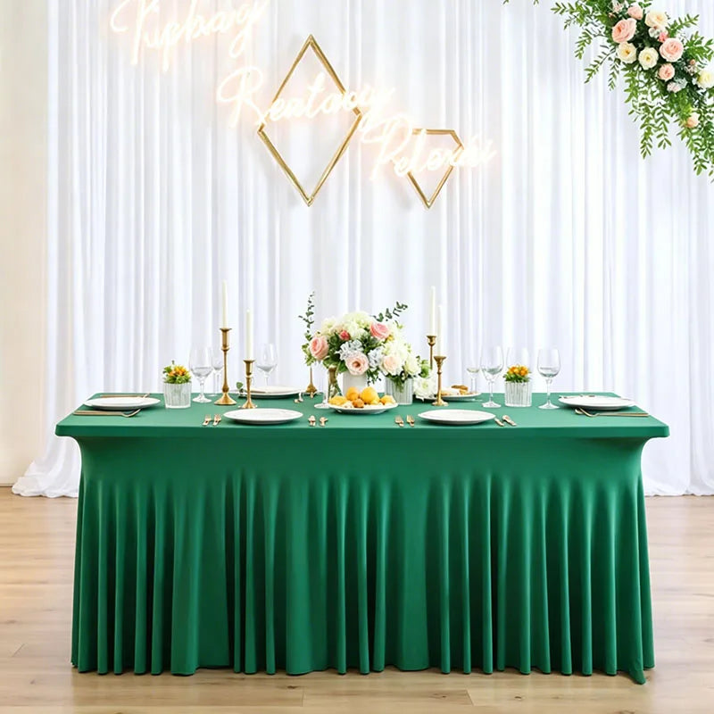 A green pleated tablecloth set for an event featuring gold geometric light fixtures and floral arrangements.