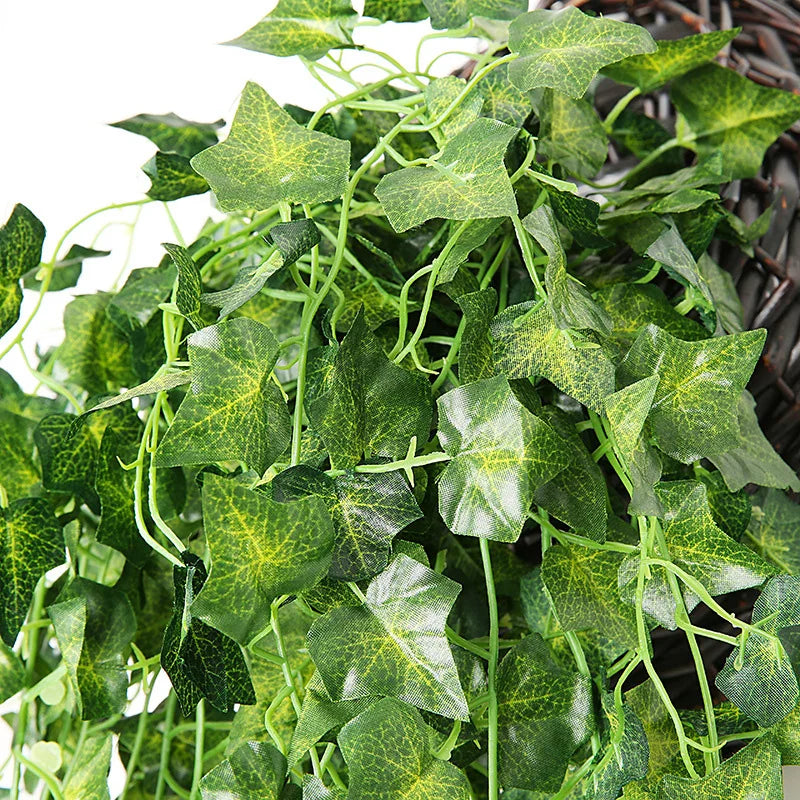 Green artificial plant vines with yellow variegation growing in a dark woven wall hanging basket.