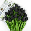 A bouquet of black artificial tulips with green stems and leaves.