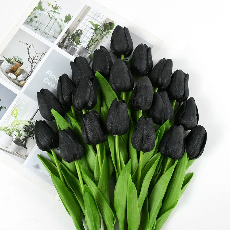 A bouquet of black artificial tulips with green stems and leaves.