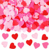 Pink and red heart-shaped sequins confetti scattered across a white background