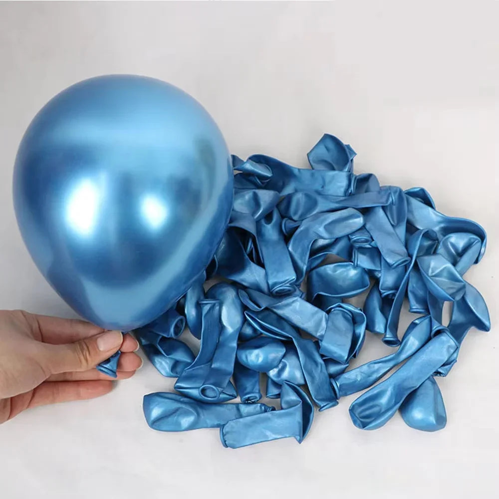 A hand holds a shiny blue football balloon and a pile of matching blue foil streamers.