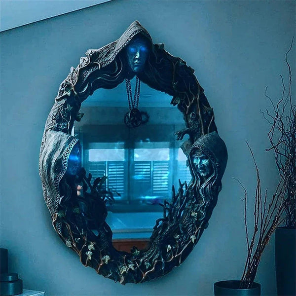 A dark, ornate mirror frame featuring a face and pentagram amulet, set against a light blue wall.