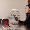 A heart-shaped acrylic plaque with a bird design and a handwritten love message on it.
