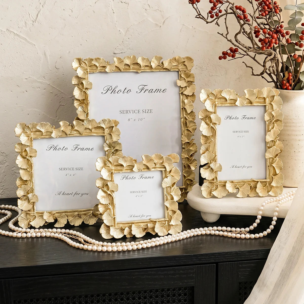 A set of gold-framed photo frames with white mats and a heart for you message displayed on a dark surface.