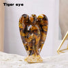 A natural crystal figurine shaped like a guardian angel with amber and gold inclusions.