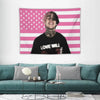A pink and white American flag tapestry featuring a person's portrait with a beard and a black shirt that reads Love Will