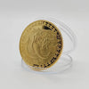A round gold commemorative iron coin featuring a zodiac animal design, displayed on a clear stand.