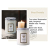 A jar of Pear Freesia scented candle with a white label and a lit candle in the background.