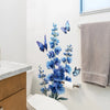 A white toilet area decorated with a blue flower and butterfly wall decal.
