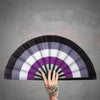 A hand is opening a colorful folding hand fan, showing the fan's pleated design.