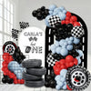 A balloon arch set featuring black, red, and blue balloons alongside stacked tires.