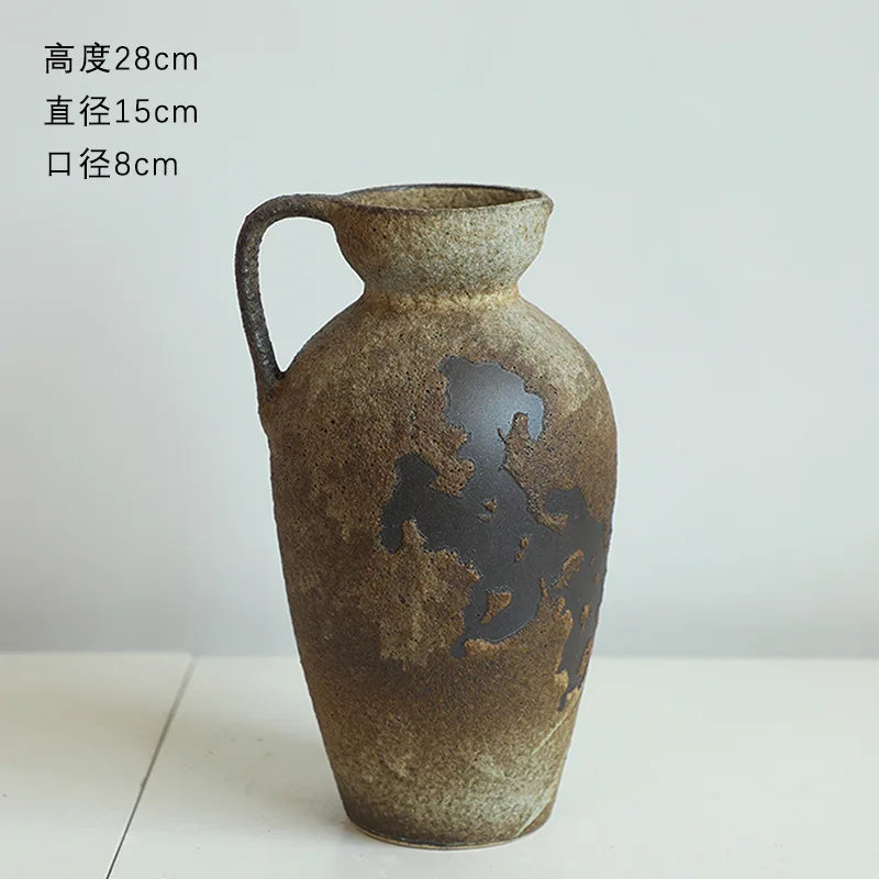 A textured, dark brown ceramic vase with a handle and an embossed map design.