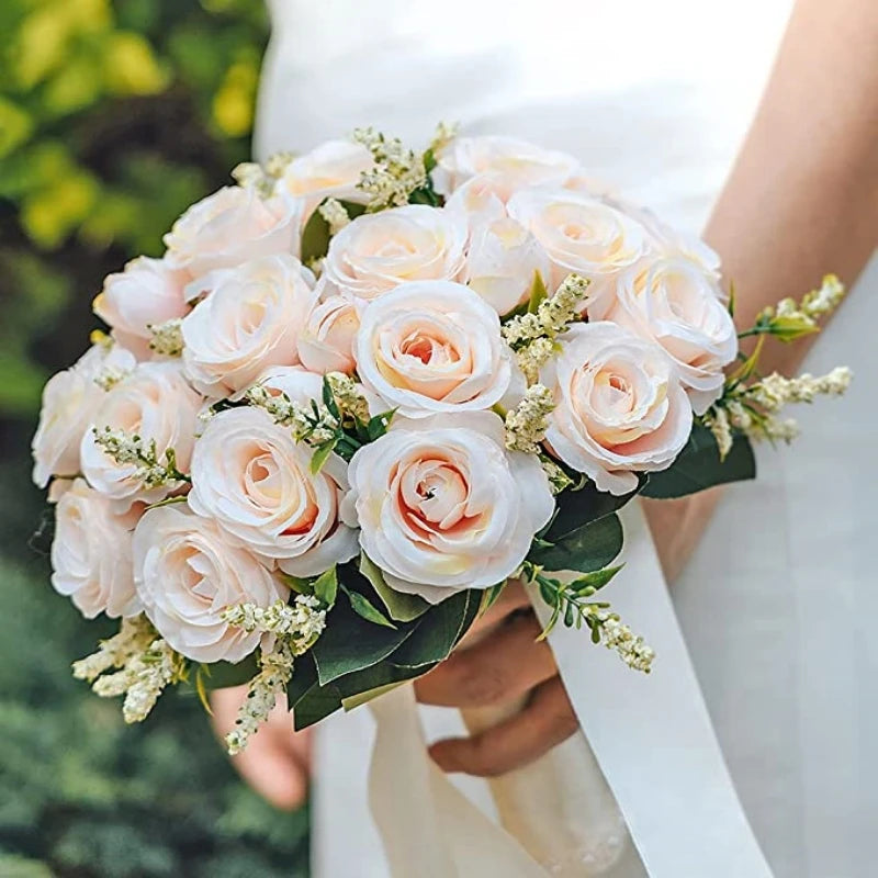 A bridal bouquet of pale pink and white silk roses held by a person.