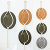 Handmade macrame hat organizer with a wooden dowel featuring various earth tones and neutral string details.