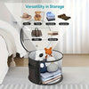 A black storage basket with a clear viewing window holds various items like hats, toys, clothes, scarves, bags, and a blanket