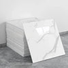 A stack of white marble tile stickers on a gray concrete surface.