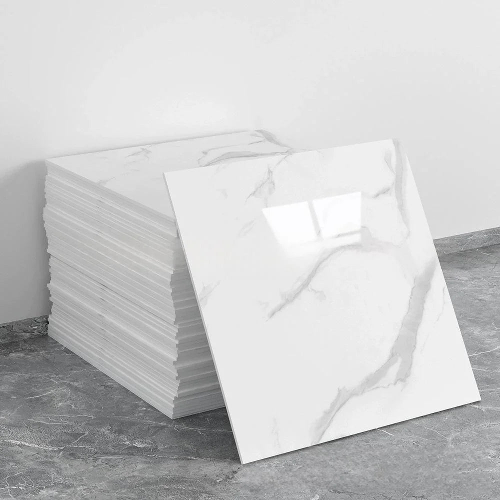 A stack of white marble tile stickers on a gray concrete surface.