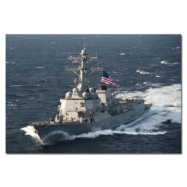A gray Bismarck-class battleship sailing through choppy blue ocean waves with an American flag flying.