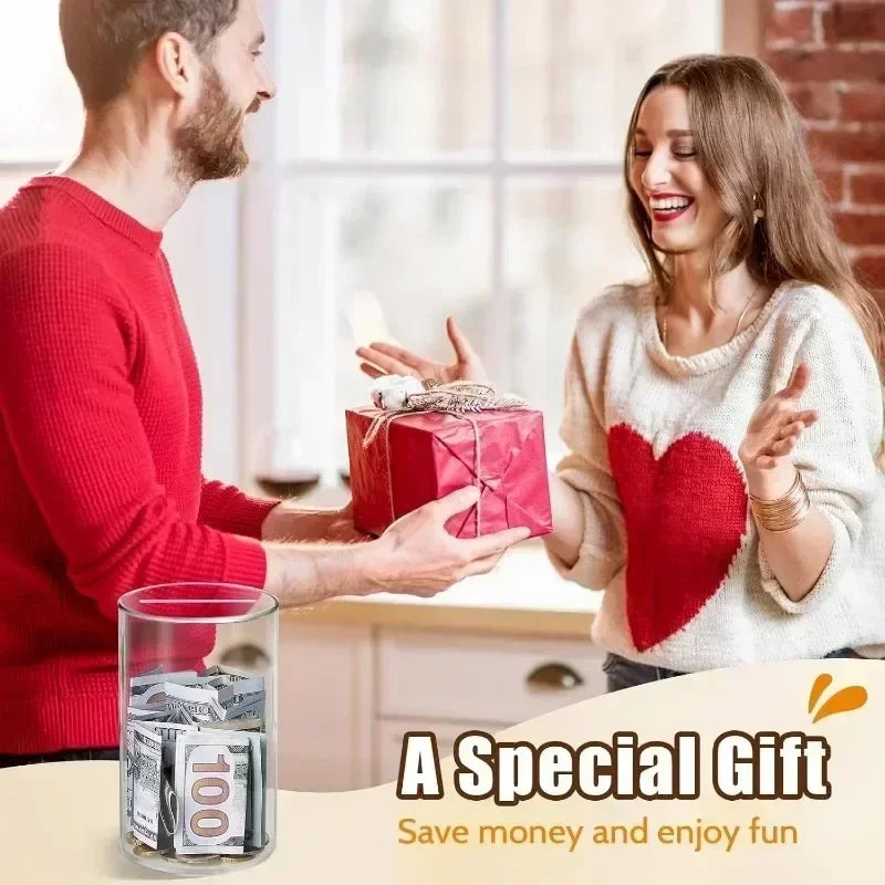 A man and a woman exchange a gift box in a bright indoor setting with a clear acrylic piggy bank visible.