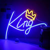 A neon sign shaped like a crown with the word King glowing bright blue on a dark background.