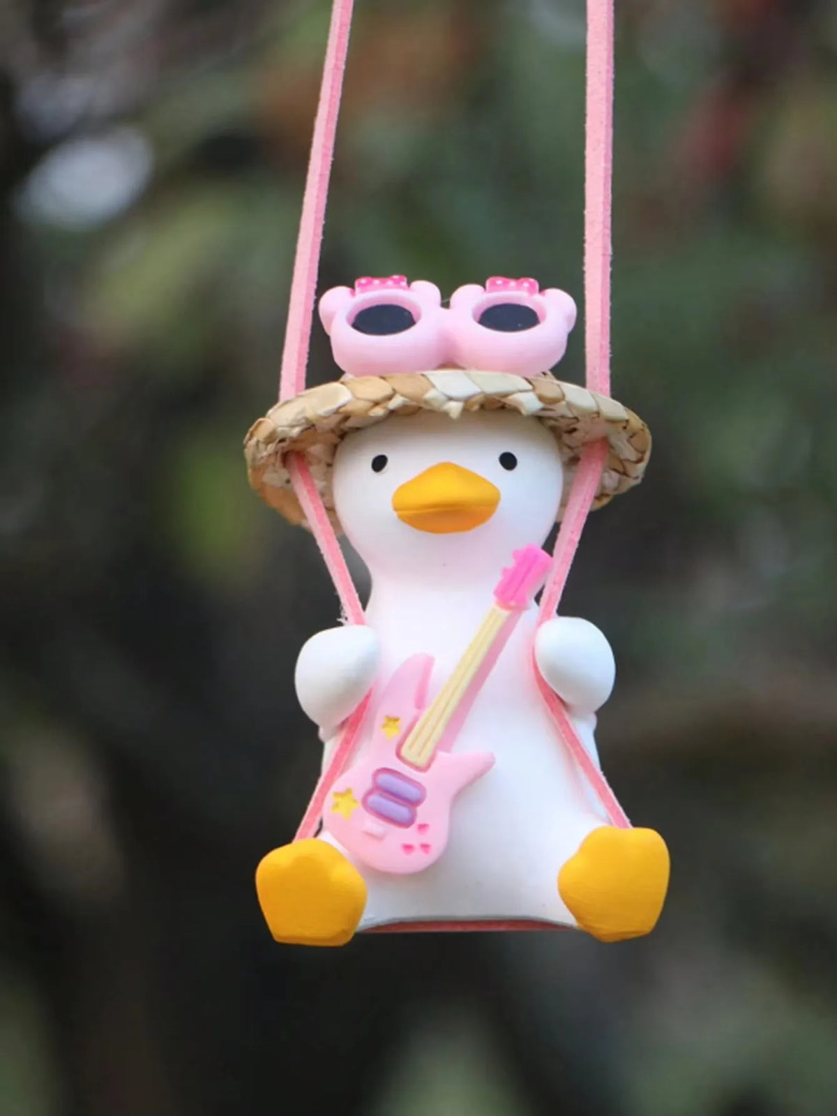 A cute pink anime duck ornament with pink goggles and a yellow beak, hanging by a pink string.