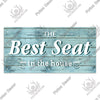 A rustic wooden sign with the text The Best Seat in the house painted on weathered blue-gray wood planks.
