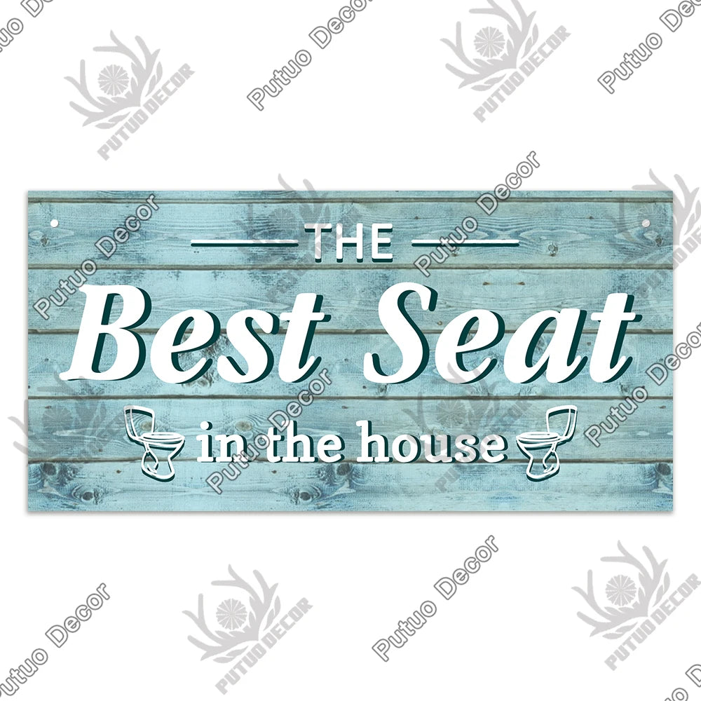 A rustic wooden sign with the text The Best Seat in the house painted on weathered blue-gray wood planks.