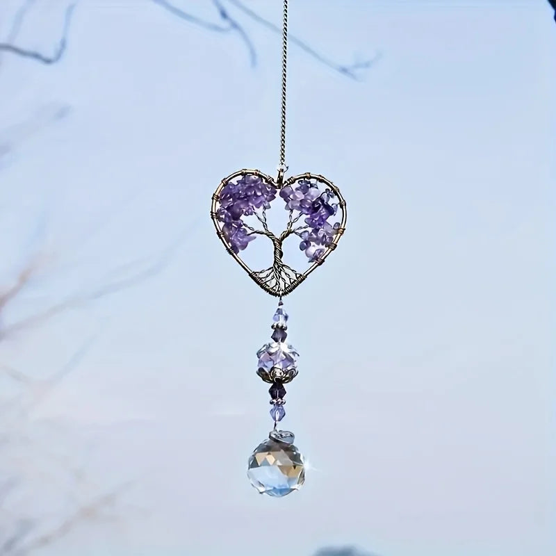 A hanging crystal tree of life sun catcher featuring purple crystals and a clear pendant.