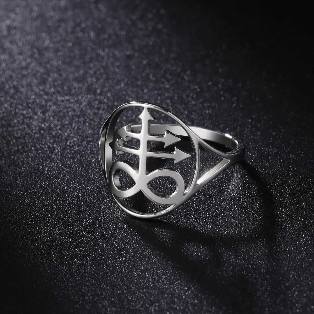 Silver signet ring featuring a Leviathan cross design resting on a dark, textured surface.