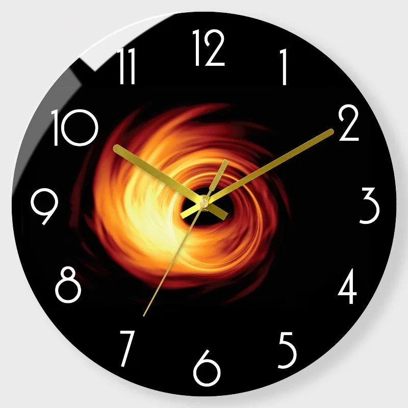 A black round clock face with a fiery orange sunburst design and gold hands.