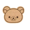 A round, light brown felt cartoon bear face with large ears and a simple nose.