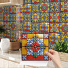 A close-up of a self-adhesive waterproof wall decal set featuring colorful, floral tiles on a tiled wall.