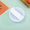 A white replacement tumbler lid is shown resting in a clear plastic cup on a light green surface.