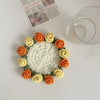 A bouquet of hand-crocheted roses in shades of orange and cream arranged on a white surface.